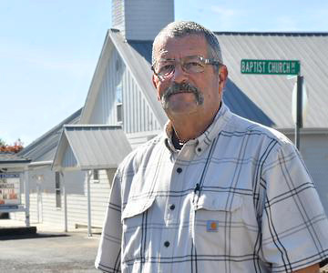 Pastor John standing outside of his church.