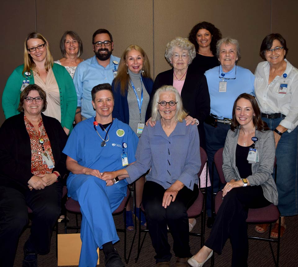 Suzy sitting with a team of caregivers from Good Samaritan Regional Medical Center.