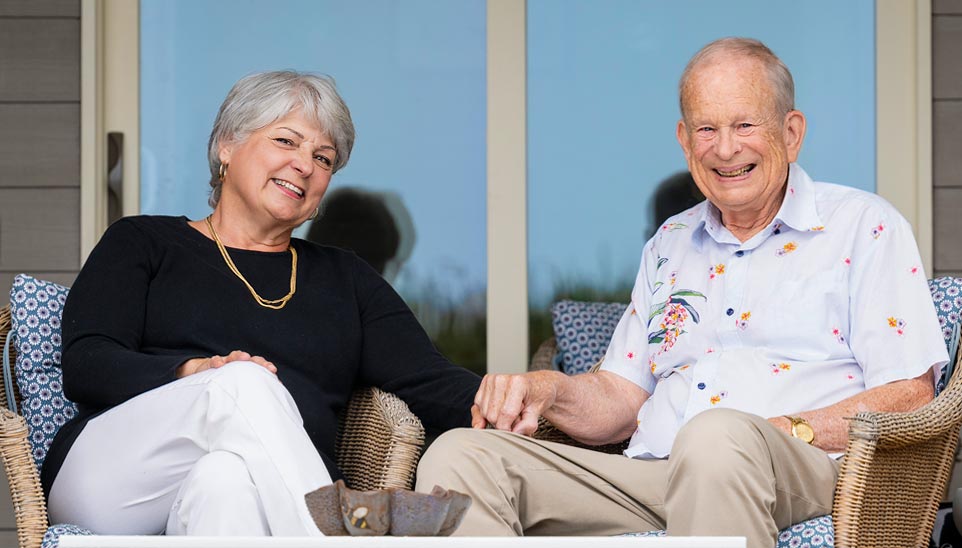 Tom and Lori sitting together on the back deck of their home.