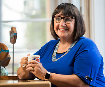 Vallie holding a cup of warm tea.