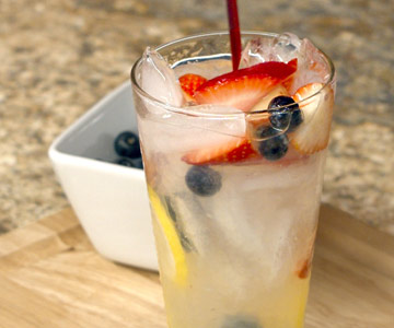Red, white and blue mocktail with dish of blueberries
