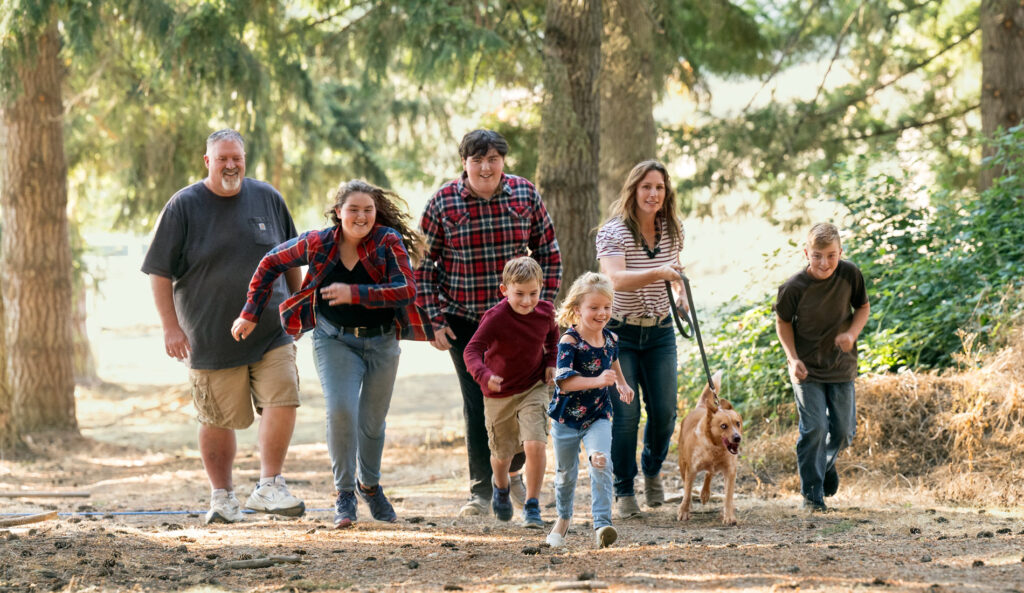 Scott and Angie with their children walking together with their family dog.