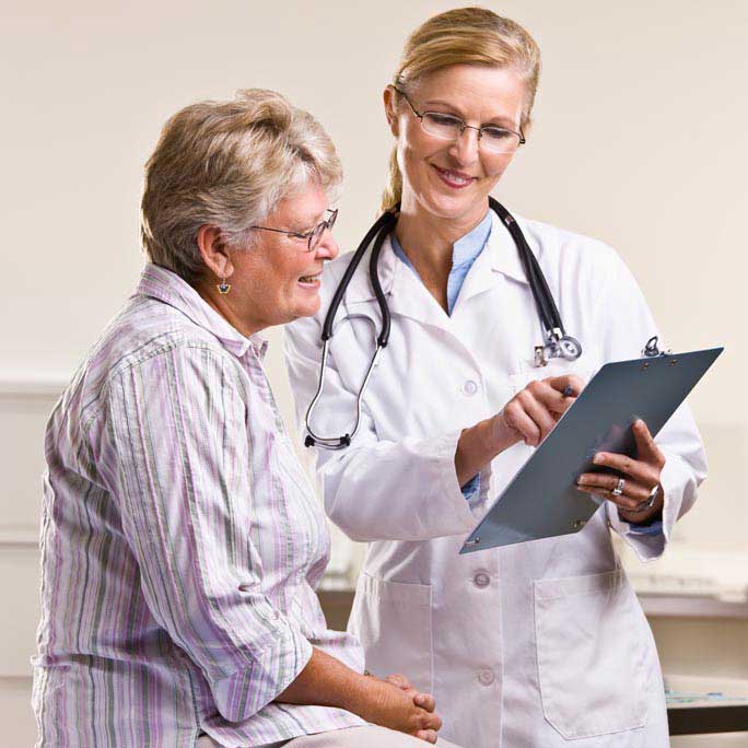 White female doctor showing a white elderly women medical information