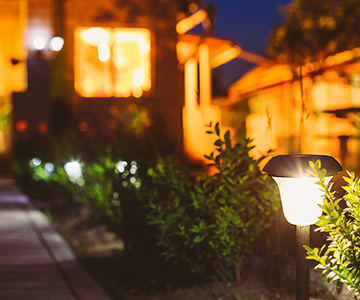 Solar lighting brightens the front pathway to the front door of a home in the evening.