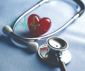 heart surrounded by a stethoscope on a table