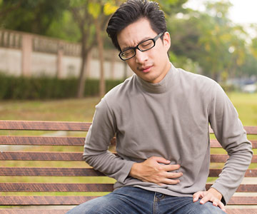 Person clenching their stomach in pain.