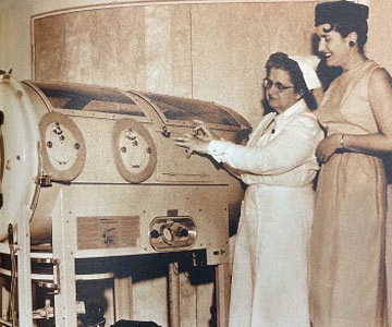 Historical photo of nurse showing patient equipment