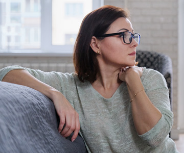 Woman wearing glasses sitting on couch