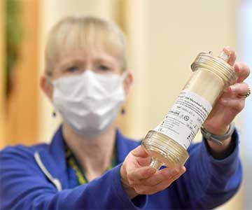 Clinician holding a treatment container for a sepsis study.