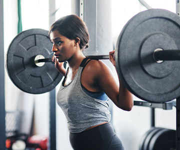 Woman lifting free weights in a gym.