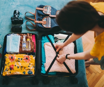 Woman packing a suitcase for a trip.