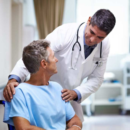 A doctor in a hospital demonstrating care for his patient by listening attentively.